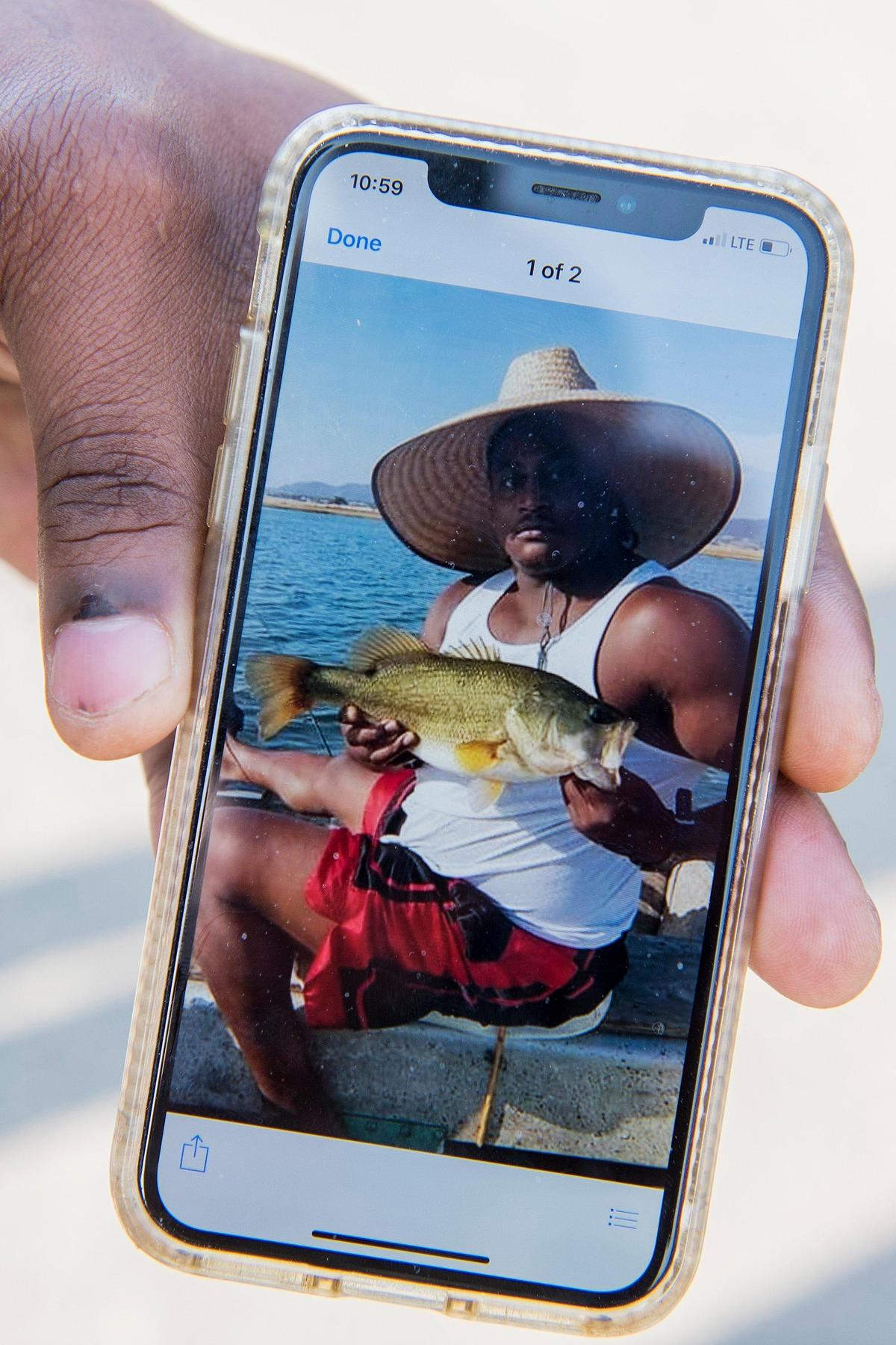 A man who did not want to be identified, displays a photo of Merced resident Lajawn Cokley on his phone as the Merced Police Department investigate a homicide and home invasion in the 400 block of Tucolay Court in Merced, Calif., on Friday, Jan. 25, 2019. A witness said Cokley was shot and killed when multiple people entered the home and stole items before fleeing the scene early Friday morning.