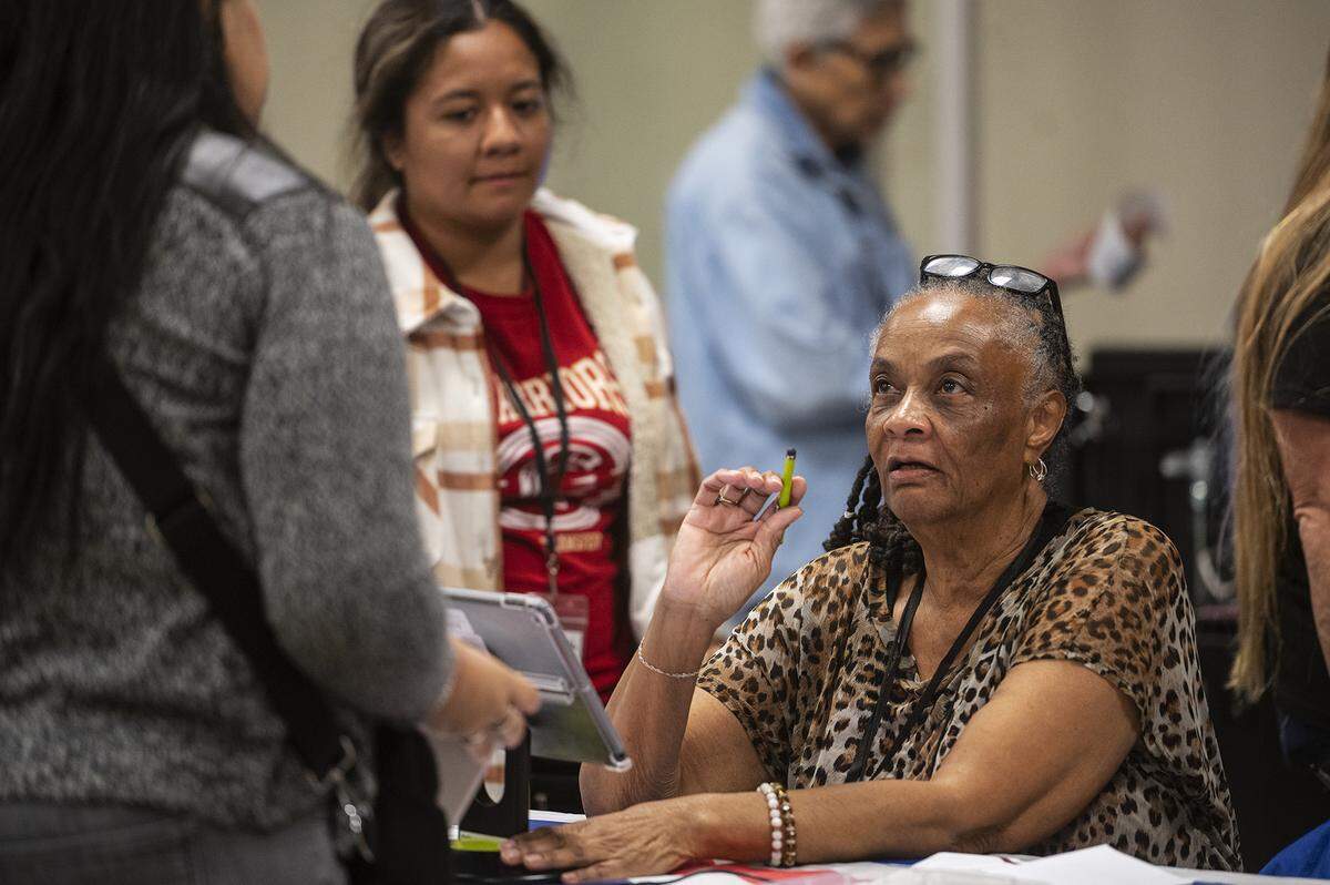 Poll worker Ianthia Guy, 73, of Merced, assists a voter checking in at Tioga Hall located at the Merced County Fairgrounds in Merced, Calif., on Tuesday, Nov. 5, 2024.