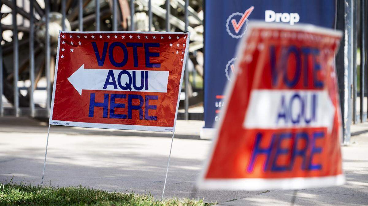 Signs indicate where to vote outside a building in Merced in 2024. 