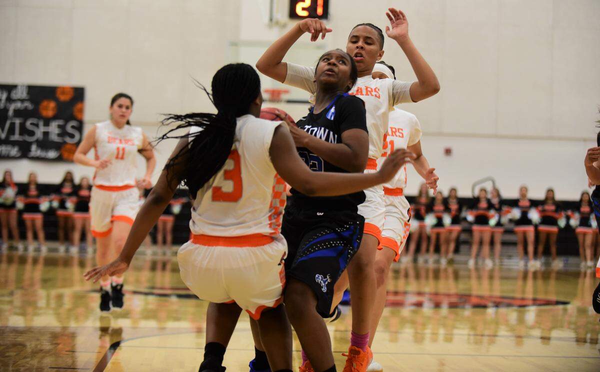Atwater High junior Amoni Claiborne drives to the basket against Merced’s Janessa Jones (3) and Amari Stamps during a game on Thursday, Feb. 6, 2020.