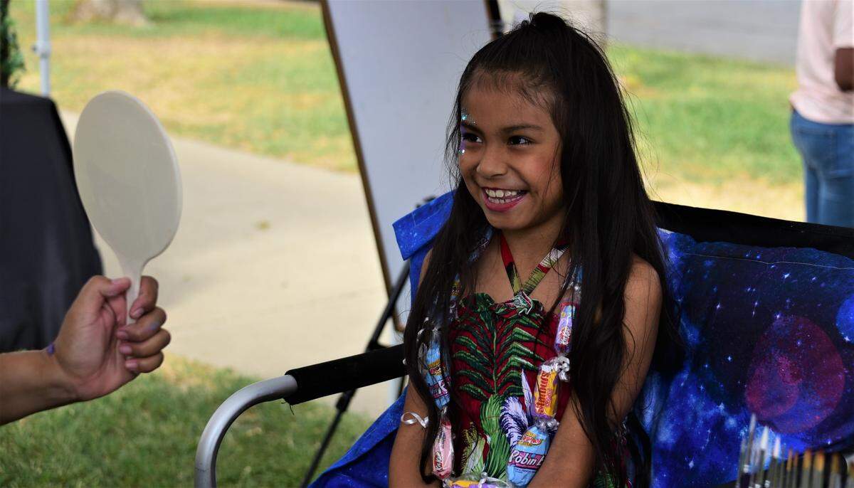 Irie Chavez, 7, of Merced reacts after seeing her face painted at the Merced County Nut Festival at the Merced County Fairgrounds on Saturday, Oct. 22, 2022.