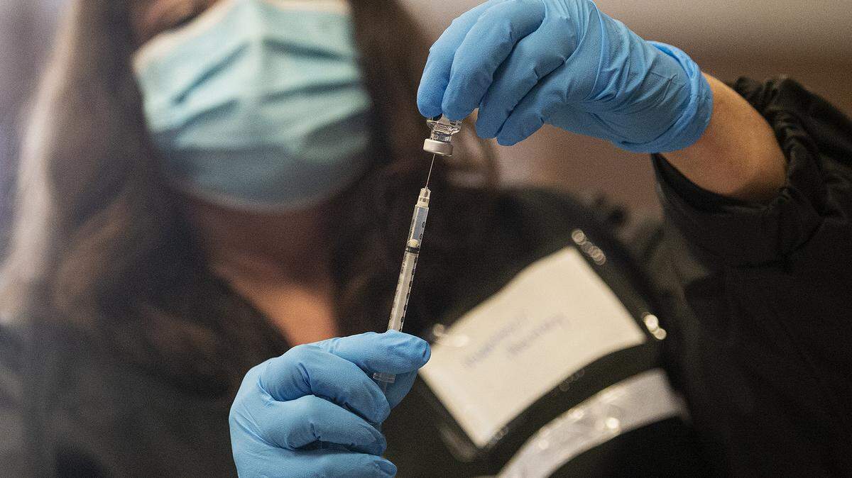 Joy Martino, a licensed vocational nurse with the Merced County Department of Public Health, fills a syringe with the Pfizer COVID-19 vaccine at a Merced County COVID-19 vaccination clinic located at the Merced County Fairgrounds in Merced, Calif., on Wednesday, Jan. 20, 2021.