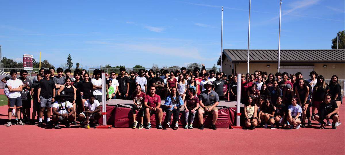 Golden Valley senior Jazmine Severo (center) is pictured with Golden Valley track and field team and coaches after Severo signed her national letter of intent to accept a scholarship to the College of Staten Island in New York on Thursday, March 22, 2022 at Golden Valley High School in Merced, Calif.