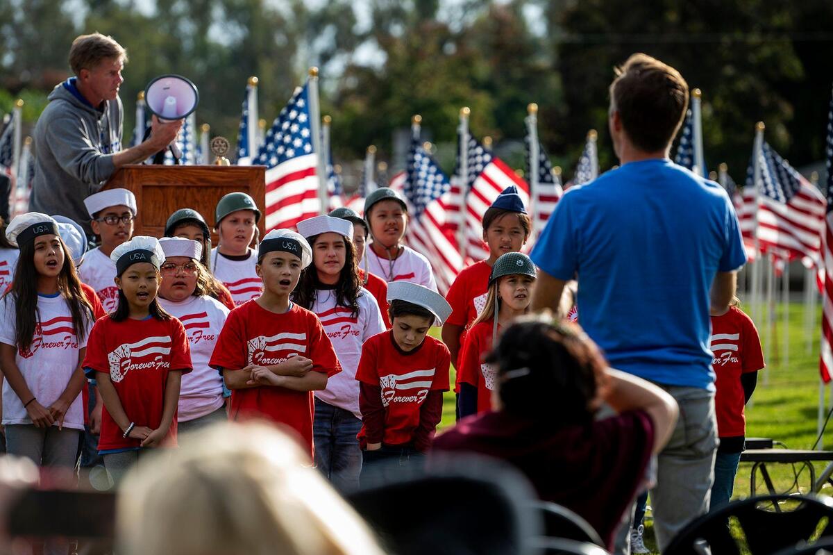 John C. Fremont Elementary School students sing during the opening ceremony for the annual Field of Honor on the Merced College campus in Merced, Calif., on Sunday, Nov. 7, 2021.