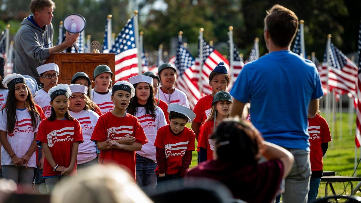 John C. Fremont Elementary School students sing during the opening ceremony for the annual Field of Honor on the Merced College campus in Merced, Calif., on Sunday, Nov. 7, 2021.