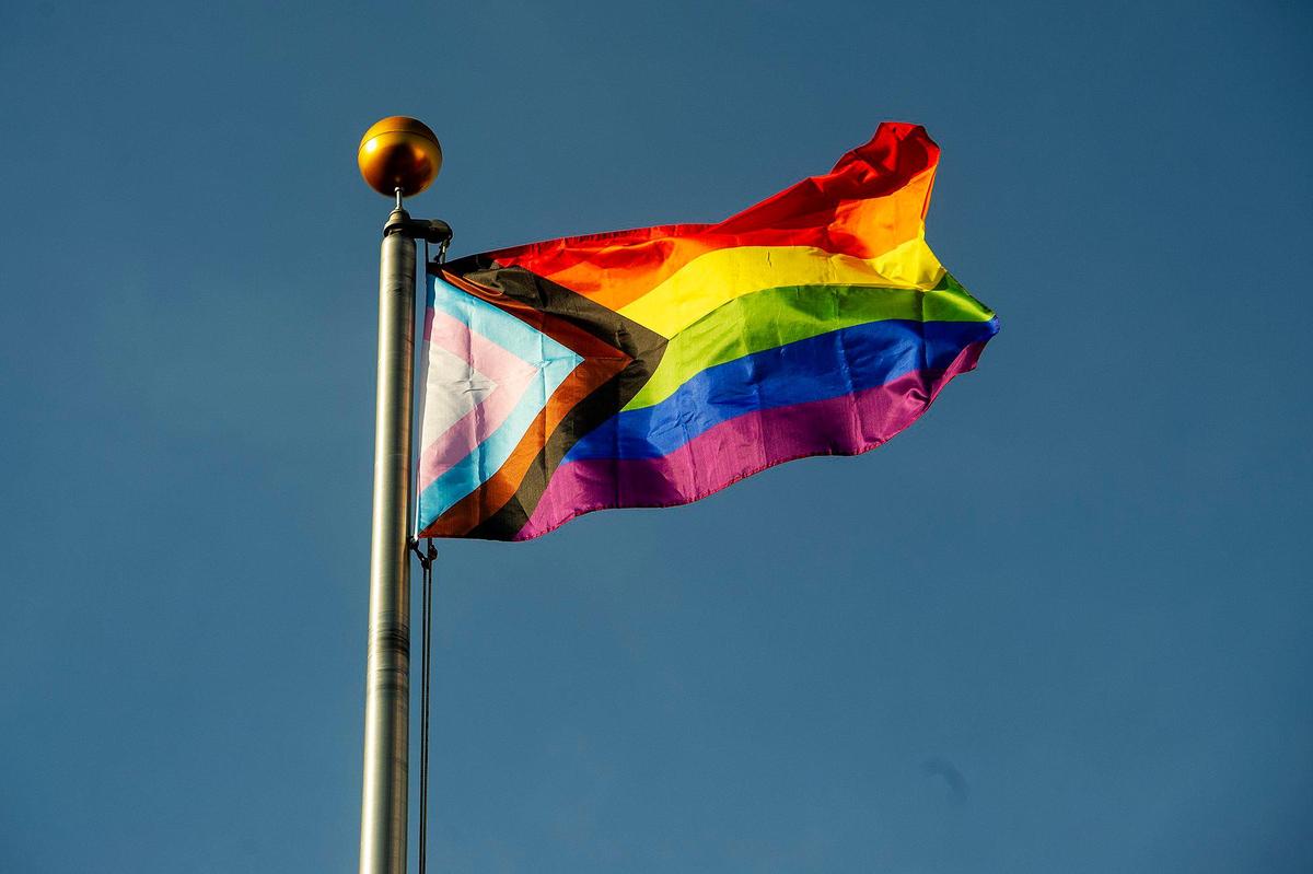 The Progress Pride flag flies over Bob Hart Square in downtown Merced, Calif., on Tuesday, June 1, 2021. A ceremony was held to celebrate the raising of the flag which contains the traditional rainbow colors as well as the transgender pride colors with a black and brown stripe to represent people of color, according to President of the Merced LGBTQ+ Alliance, Adam Lane.