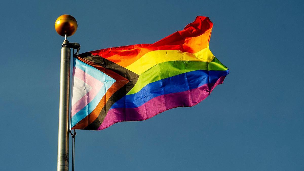 The Progress Pride flag flies over Bob Hart Square in downtown Merced, Calif., on Tuesday, June 1, 2021. A ceremony was held to celebrate the raising of the flag which contains the traditional rainbow colors as well as the transgender pride colors with a black and brown stripe to represent people of color, according to President of the Merced LGBTQ+ Alliance, Adam Lane.