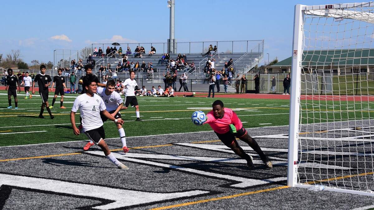Le Grand’s Frankie Coria (4) and Brian Lua (8) look on as Encina goalie Davel Perry punches away a Bulldogs’ shot during the Sac-Joaquin Section Division VI championship game at Liberty Ranch High School on Saturday in Galt.