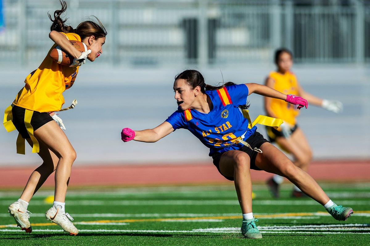 Blue All-Star Kalli Hoffman (20) representing Central Valley, attempts to stop Gold All-Star Julissa Guzman (6) representing Merced, during the Merced County All-Star Girls Flag Football Game at Golden Valley High School in Merced, Calif., on Saturday, June 15, 2024. The Blue All-Stars beat the Gold All-Stars 20-12.