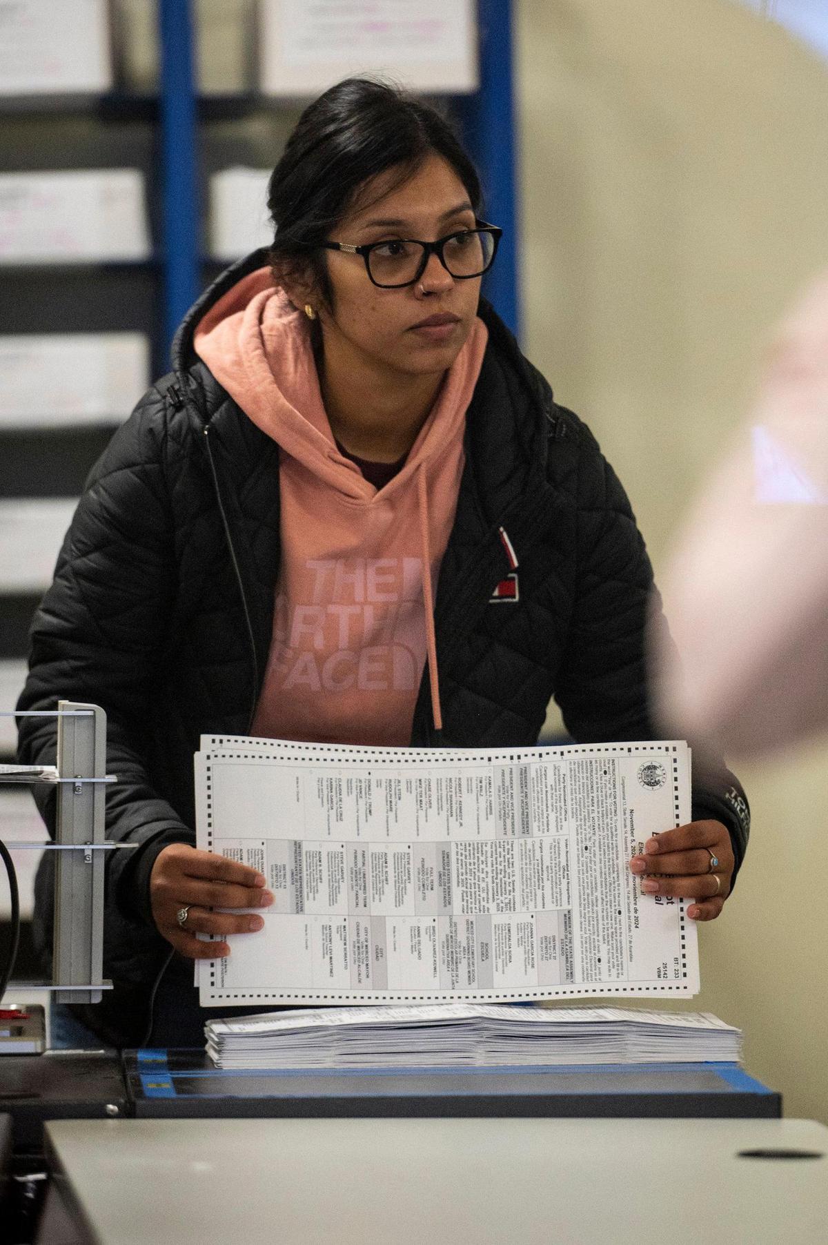 Election specialist 1 Claudia Carranza, 27, of Merced, organizes a stack of ballots that were run through a tabulator machine, at the Merced County Election Warehouse in Merced, Calif., on Thursday, Nov. 7, 2024. Election officials and workers continue to count tens of thousands of ballots following the Nov. 5, General Election.