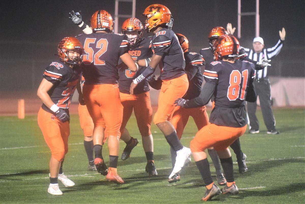 The Merced High defense celebrates after Jalonn Booth (52) returns an interception 34 yards for a touchdown during the Bears’ 56-15 win in the second round of the Sac-Joaquin Section Division IV playoffs on Friday, Nov. 12. 2021 at Veterans Stadium in Merced, Calif.