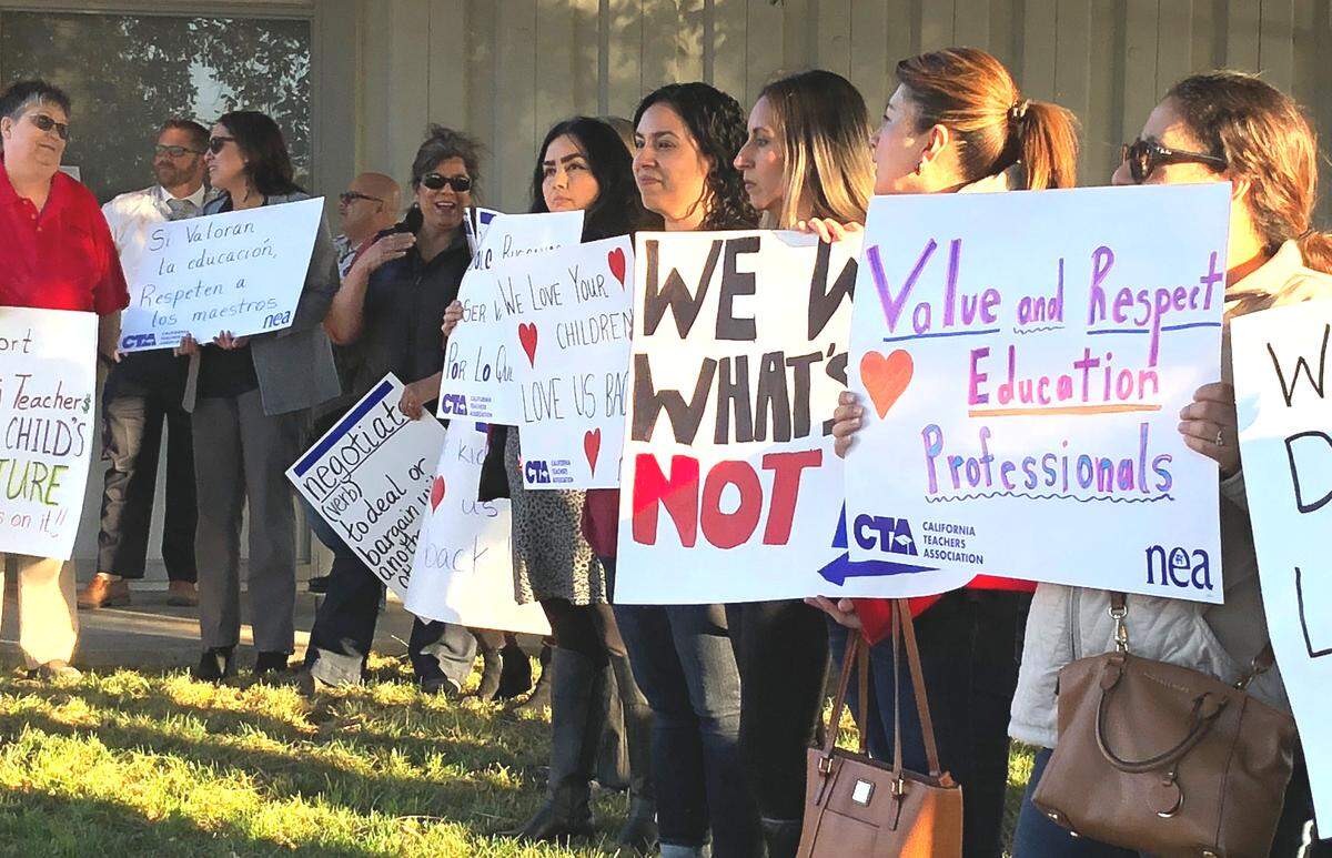 Teachers and supporters stand outside the Delhi Unified School District board conference room at 16091 Locust St. before a board meeting on April 9, 2019, with signs in support of the Delhi Teachers Association and its fight to give teachers a 3.7 percent raise. Contract negotiations with the school district administration were declared at an impasse on March 28, according to teachers union representatives.