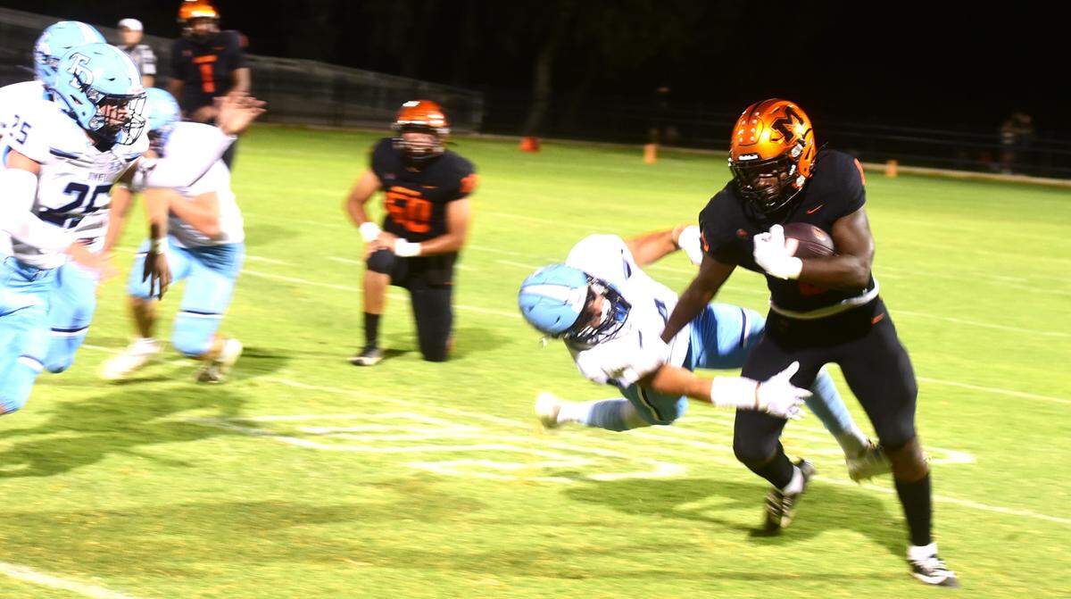 Merced High running back Cammarri Jackson (8) sheds a Downey defender and runs up field during a game on Friday, Sept. 6, 2024.