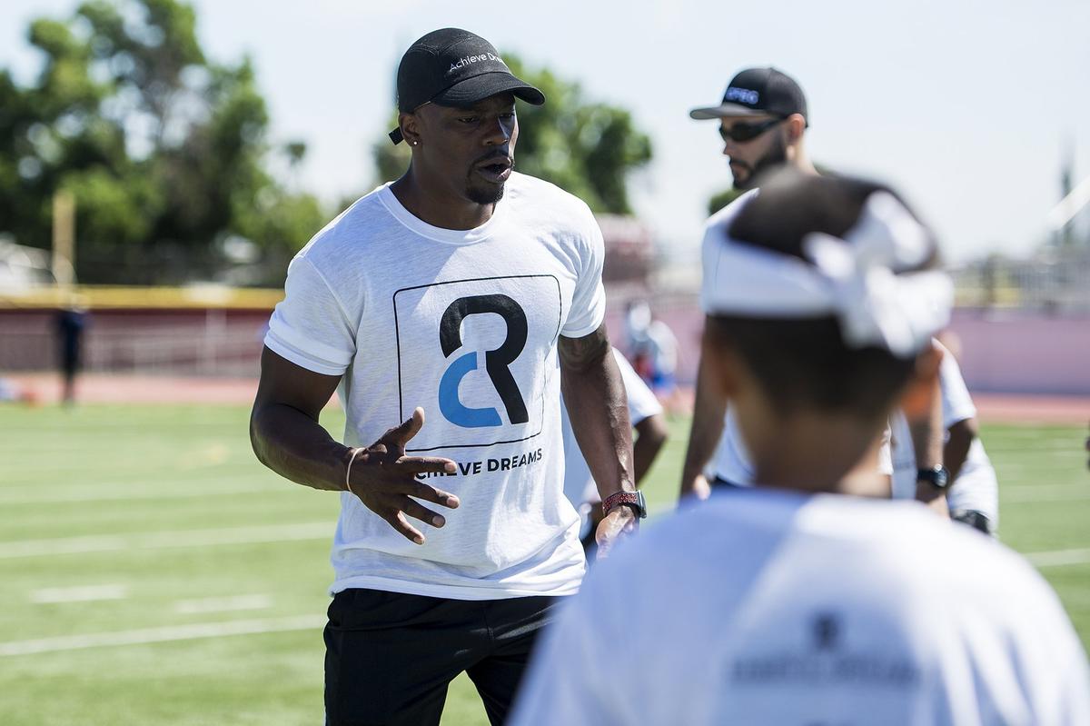 Canadian Football League all-star and Golden Valley graduate Chris Randle, instructs children on proper footwork during the Achieve Dreams Youth Football Camp at Veterans Stadium on the campus of Golden Valley High School in Merced, Calif., on Saturday, May 12, 2018. This is the second year Randle has hosted the camp which is offered free of charge to children ages 6-18.