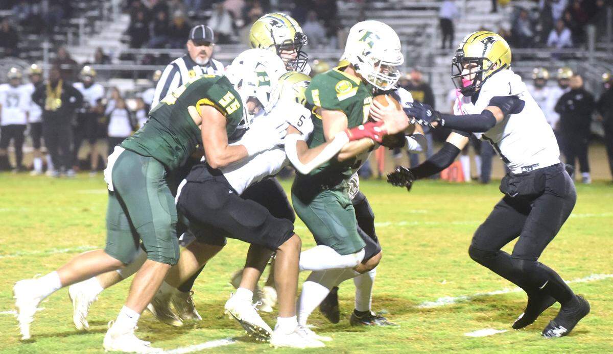 Pioneer High School defenders work to bring down Hilmar senior running back Logan Cardoso during the Yellowjackets’ 41-32 playoff win on Thursday, Nov. 9, 2023.