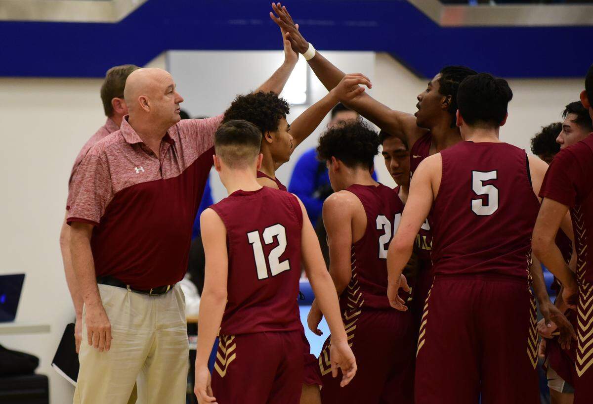Golden Valley basketball coach Keith Hunter left gives senior Aurrion Harris a high-five during a timeout. The Cougars defeated Atwater 71-35. It was the 450th career win for Hunter and the GV basketball program.