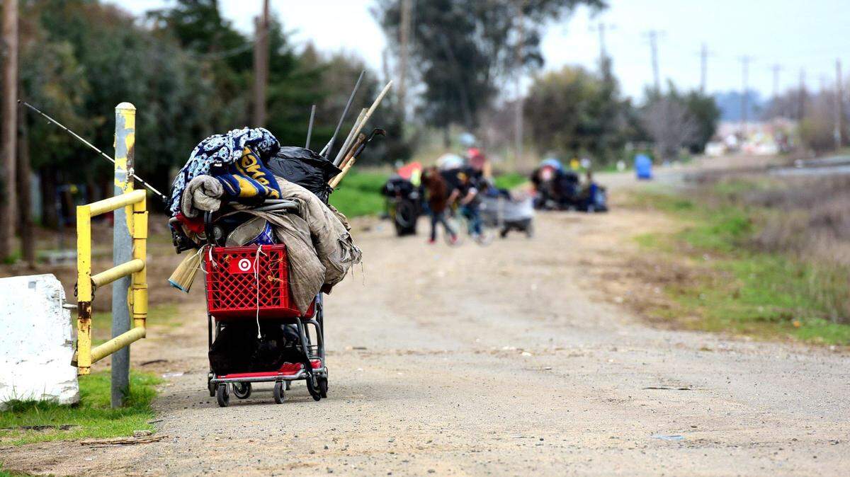 A few homeless people move their belongings across Highway 59 on Friday, March 1, 2019.