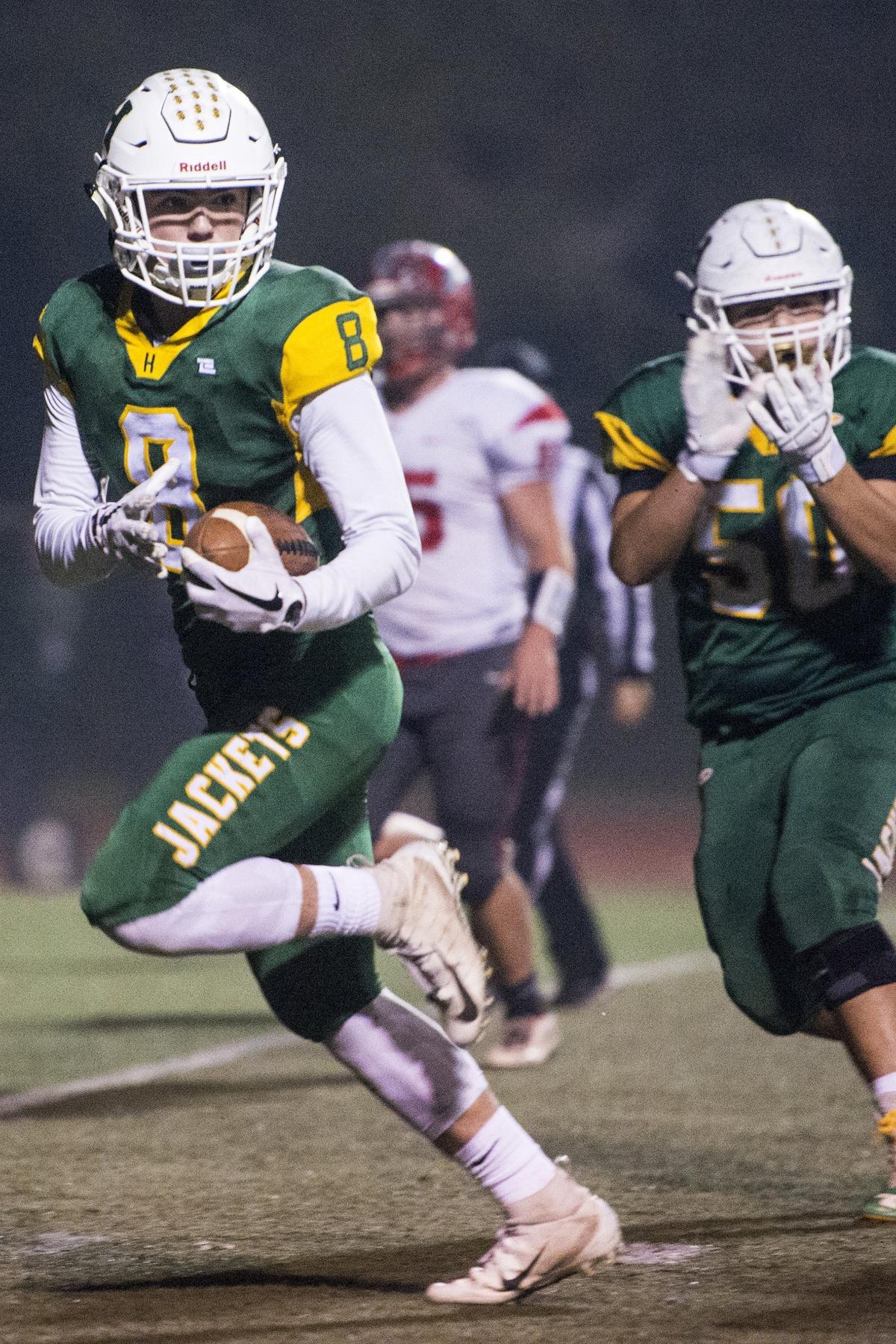 Hilmar senior Noah Barcelos (8) looks back at defenders as he scores a touchdown during the Northern California 6-AA Championship game against East Nicolaus at Atwater High School in Atwater, Calif., on Friday, Dec. 7, 2018. The Yellowjackets beat the Spartans 48-14.