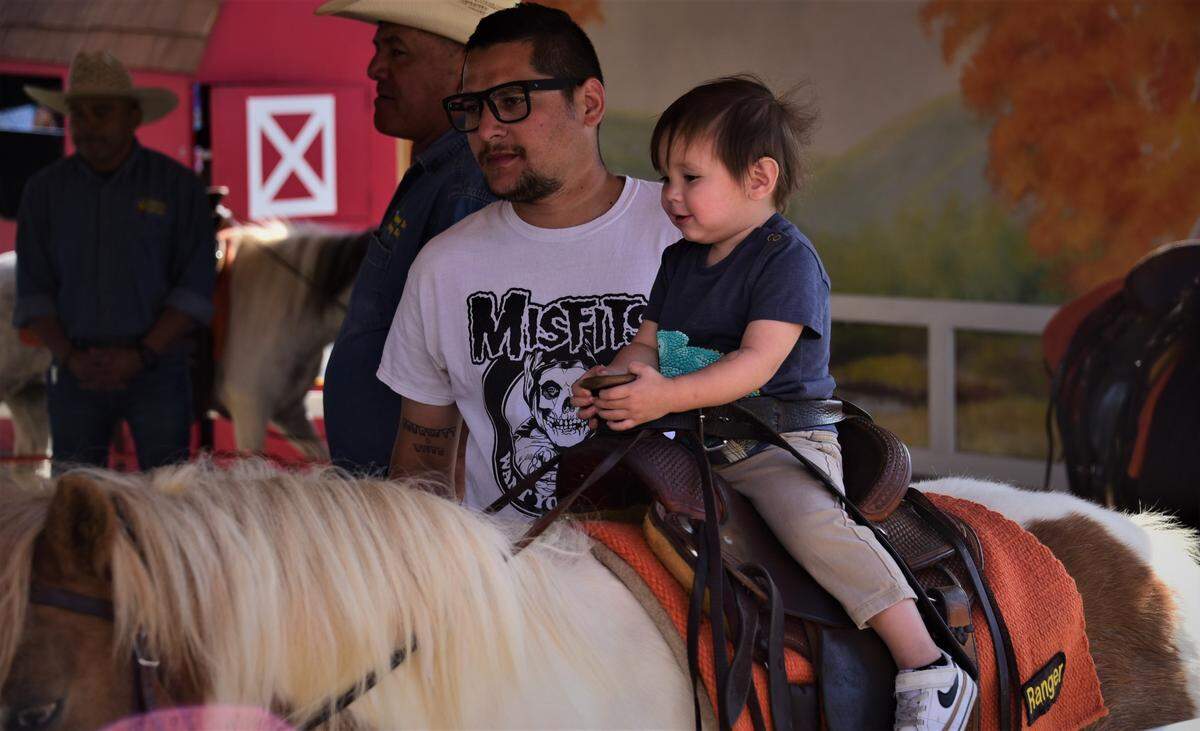 One-year old River Romero rides a pony while his father Robert Romero walks along side on the opening day of the Merced County Spring Fair in Los Banos on Wednesday, April 27, 2022 in Los Banos, Calif.