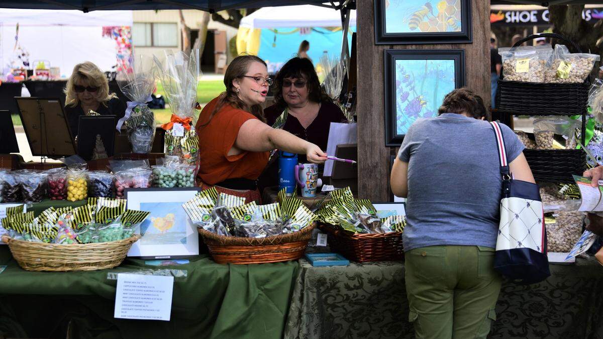 People shop at the Buchanan Hollow Nut Co. booth at the Merced County Nut Festival on Saturday, Oct. 22, 2022 at the Merced County Fairgrounds.