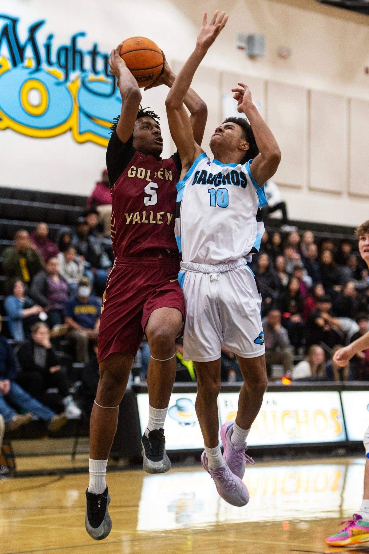 Golden Valley junior Zay Goode (5) attempts a layup while defended by El Capitan junior Jay Ervin (10) during a game at El Capitan High School in Merced, Calif., on Wednesday, Feb. 12, 2025. The Cougars beat the Gauchos 66-58 in double overtime.
