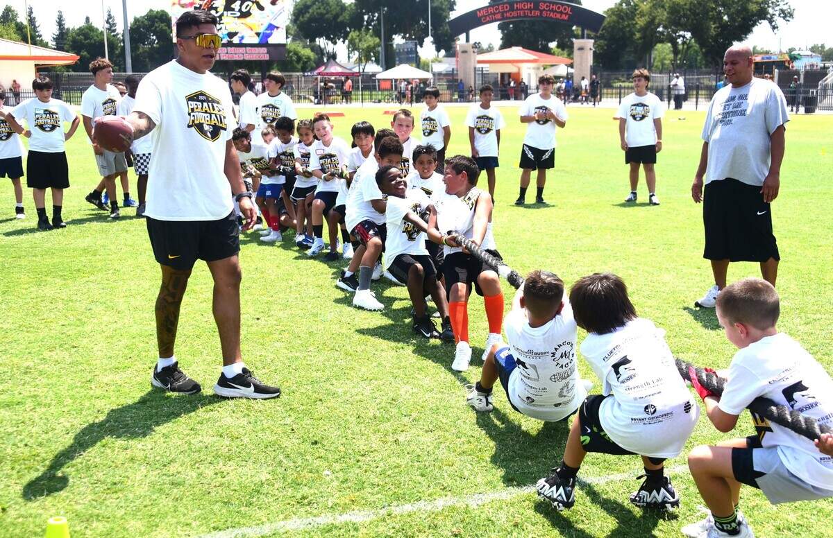 Kids compete in a tug-of-war competition at the David Perales Football Camp held at Merced High School on Saturday, July 13, 2024 in Merced, Calif.