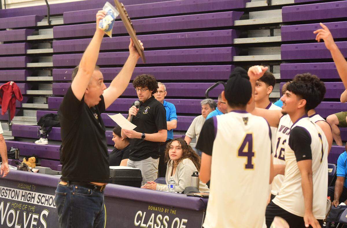 Livingston High boys volleyball coach Mike Alvernaz raises the Northern California Division IV championship plaque as he celebrates with players after the Wolves’ defeated Oakland High 3-1 on Saturday, May 24, 2025 at Livingston High School.