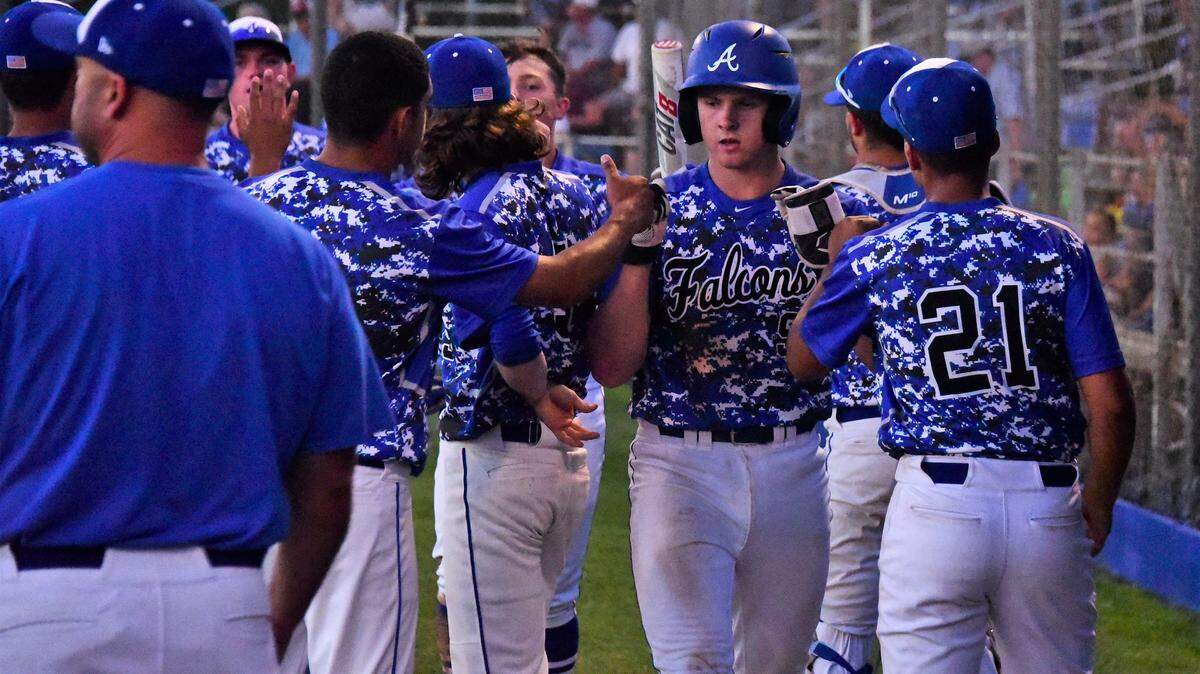 Jacob Weiss is congratulated by his Atwater teammates after scoring a run during the Falcons’ 12-6 win over Downey on Tuesday, April 23, 2019 at Memorial Ballpark in Atwater, Calif.