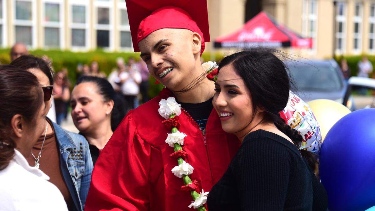 Gustine High School senior Brian Ortiz Nunez greets his sister Alondra Ortiz Nunes after he received his diploma during a special graduation ceremony on Friday, April 12, 2024. Brian Ortiz Nunez is batlting a rare, terminally-ill cancer.