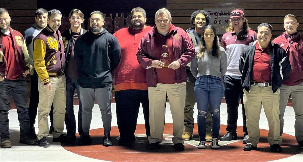 Golden Valley High School wrestling coach Chopper Mello is joined by many of his former wrestlers during a ceremony honoring Mello for his 400th career win on Tuesday, Jan. 17, 2023 at Golden Valley High School.
