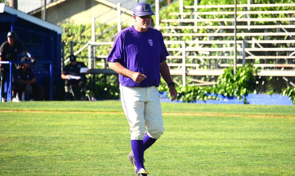 El entrenador de beisbol de Livingston High, Matt Winton, regresa al dugout después de hacer un cambio de lanzador durante un partido contra los Enochs, el martes 2 de abril de 2024, en el Memorial Ballpark en Atwater, California.