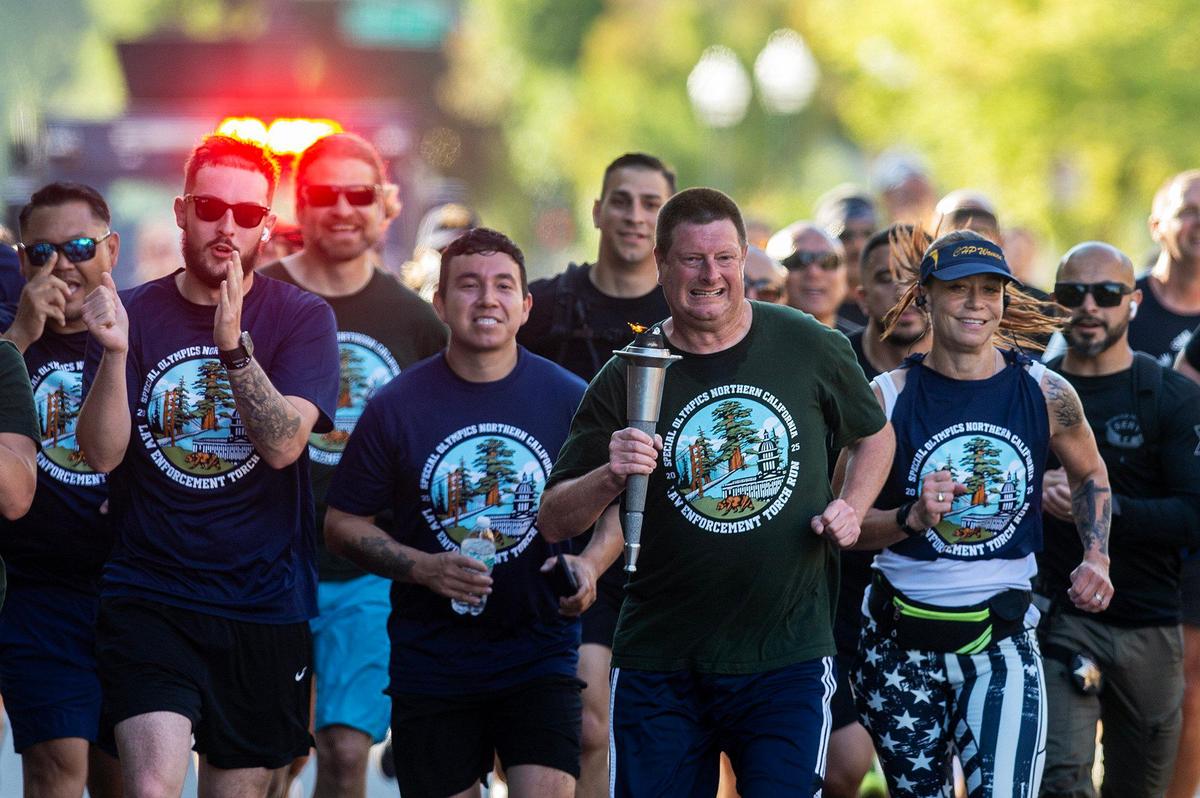 Merced resident and Special Olympics athlete Mark Heffner, 43, leads a pack of runners along West 18th Street while carrying the torch with the “Flame of Hope” during the annual Law Enforcement Torch Run for Special Olympics Northern California in Merced, Calif., on Wednesday, June 25, 2025.