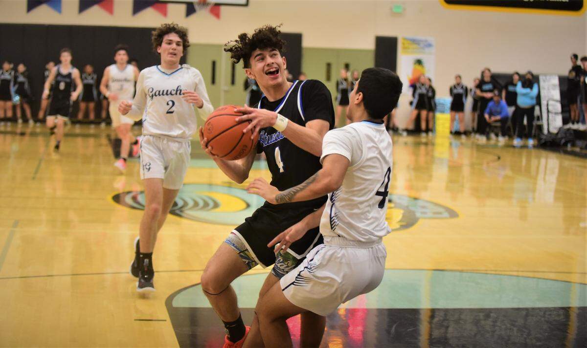 El Capitan High senior Ceaser Manzo (4) draws a charge from Atwater’s KJ Ross (4) during a game on Friday, Jan. 13, 2023 at El Capitan High School in Merced, Calif.