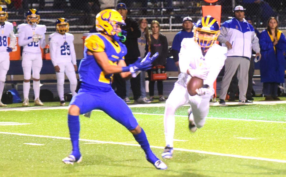 Exeter High School sophomore defensive back Joseph Ruiz (7) comes up with an interception during a playoff game against Dos Palos on Friday, Nov. 17, 2023 at Dos Palos, Calif.