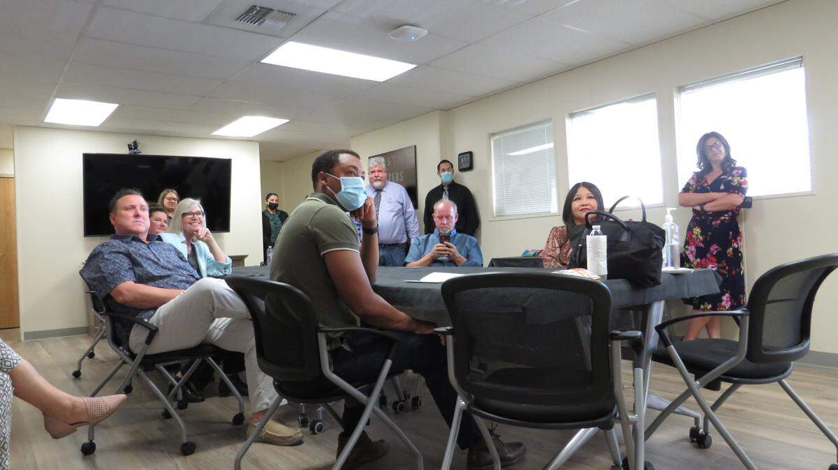 Several attendees listen to Tristin Gresham, the probation program specialist for Breaking Barriers, explain the purpose of the program at its first open house Friday, July 23, 2021, in Los, Banos, California.