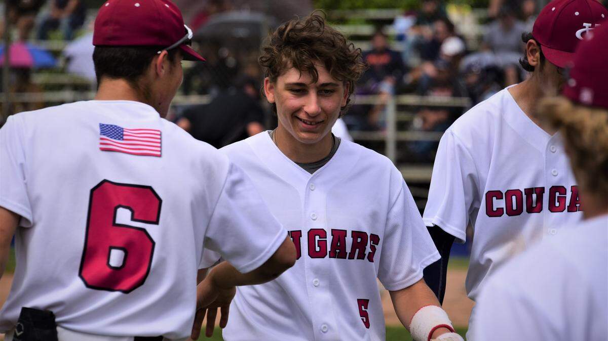 Golden Valley sophomore Austin Mello (center) is greeted by teammates after scoring the tying run in the fifth inning during an 8-7 win over Livingston on Monday, April 18, 2022 at Memorial Ballpark in Atwater, Calif.