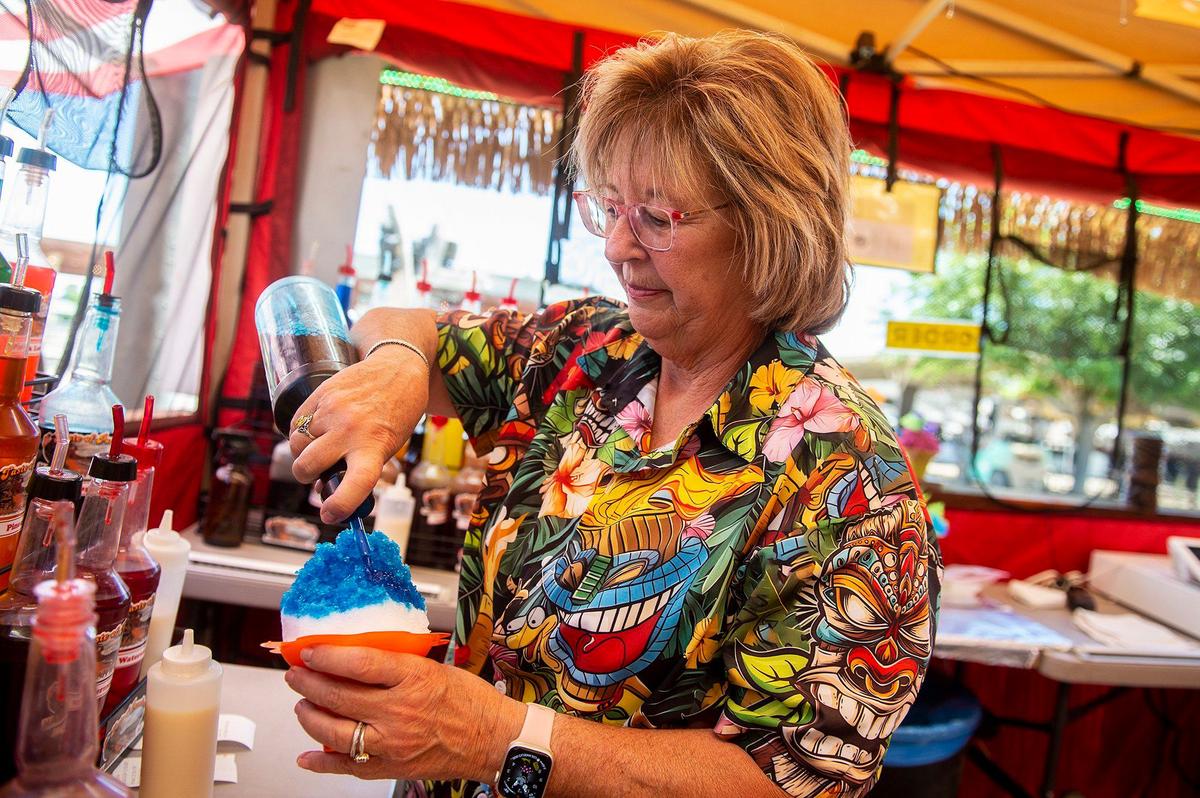 Kim Sanders, 65, of Clovis, prepares a shave ice for a customer at the Hawaiian Shave Ice stand at the Merced County Fair in Merced, Calif., on Thursday, June 6, 2024.