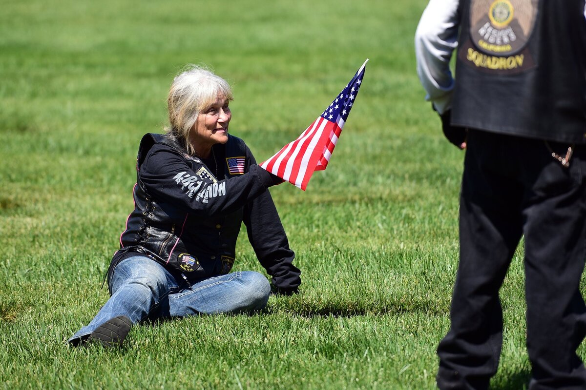 Renae Frye, 55, of Turlock sits next to the headstone of her husband, William L. Cozine Sr., on Sunday, May 27, 2018, at San Joaquin Valley National Cemetery in Santa Nella following a ceremony for Memorial Day. Cozine, who died in 2005, was a Marine who served during the Vietnam War, according to his wife.