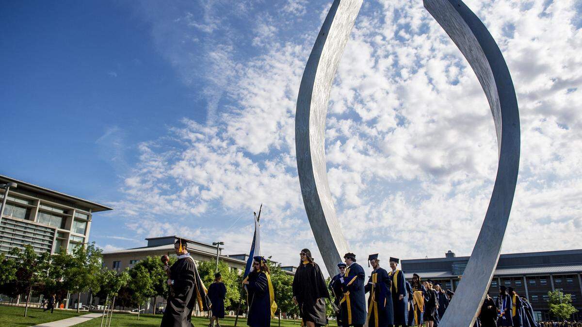 University of California, Merced graduates walk through the campus sculpture titled “Beginnings” during commencement for the school of Social Sciences, Humanities and Arts at UC Merced in Merced, Calif., Saturday, May 14, 2016.