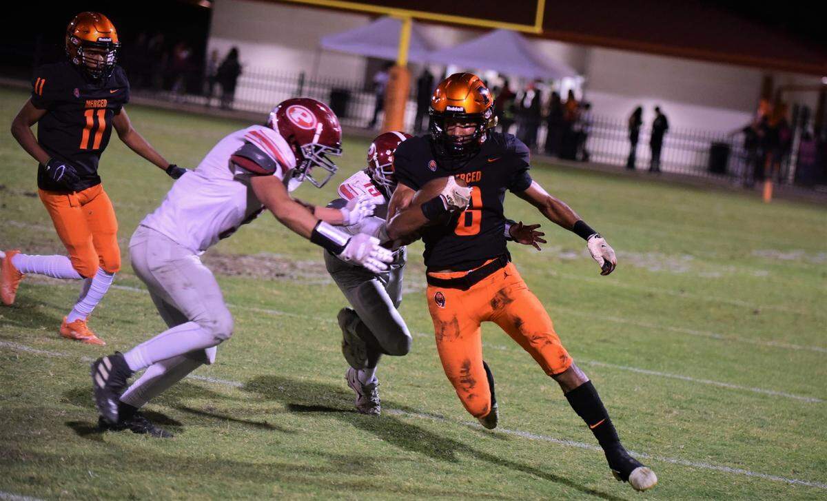 Merced High senior Enoch Evans runs the ball up field during a game against Patterson on Friday, Sept. 23, 2022.