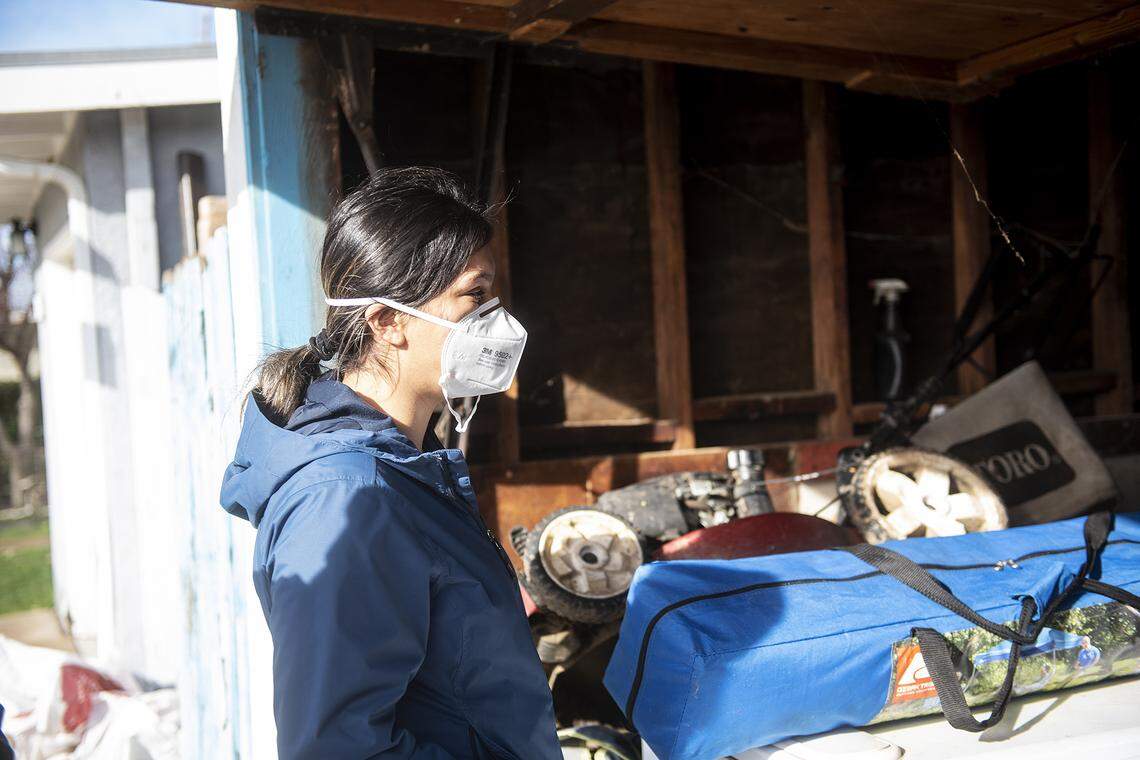 Isabel Ramirez, 24, looks at items damaged by floodwater in a garage at her home in Planada, Calif., on Thursday, Jan. 12, 2023. Ramirez recently returned to her home after the Merced County Sheriff’s Office downgraded an evacuation order to a warning.