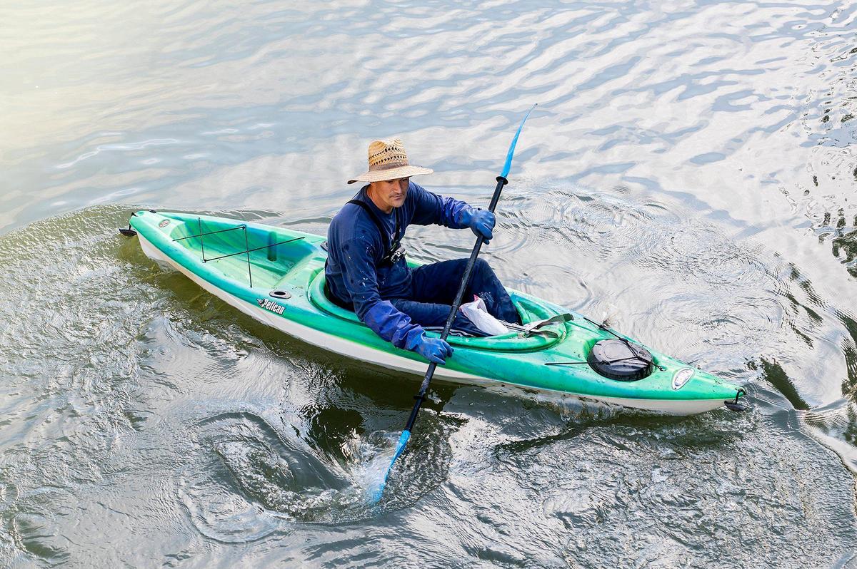 Merced Mayor Matthew Serratto uses a kayak to collect trash and other debris from along the banks of Bear Creek during a cleanup event presented by the Merced non-profit Bear Creek Yacht Club, in Merced, Calif., on Saturday, Oct. 14, 2023.