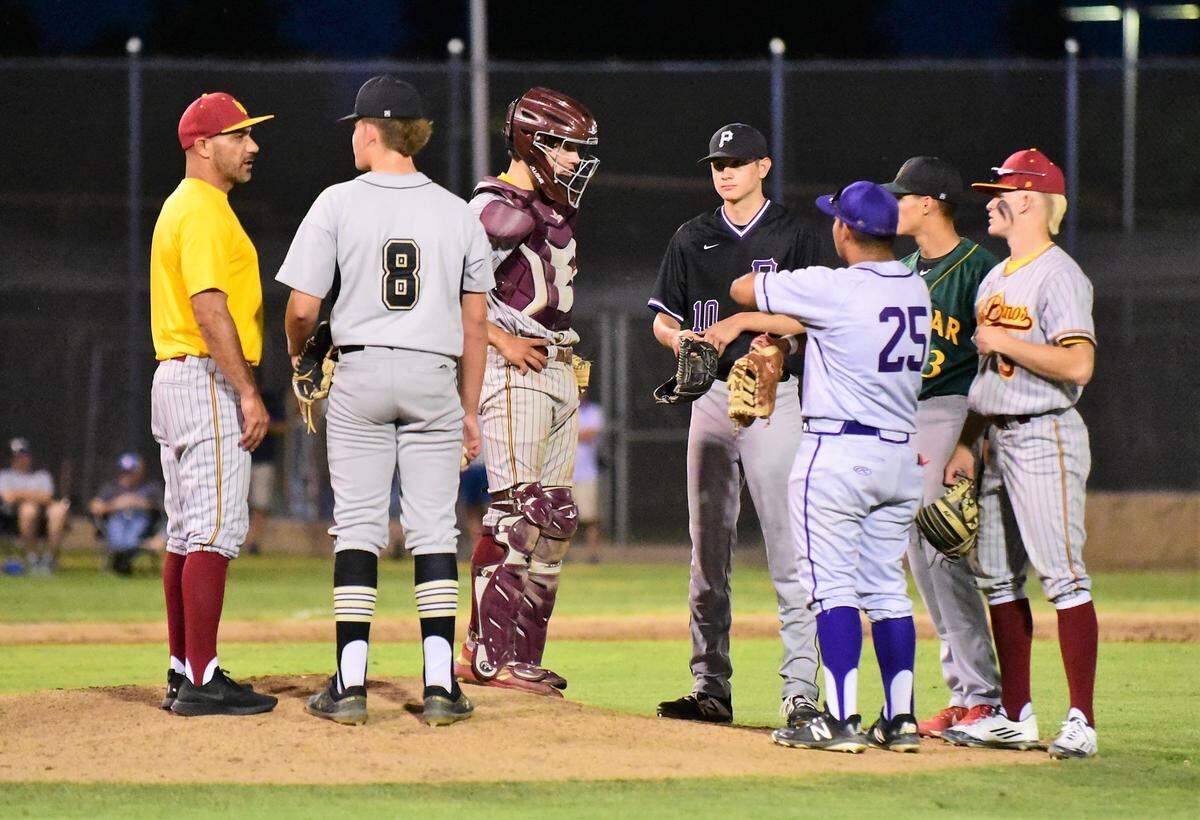 Los Banos High coach Pat Fuentes makes a trip to the mound to talk to Buhach Colony sophomore Jake Sapien as the rest of the North infield meets during the 10th annual Merced County All-Star Game on Saturday, June 8, 2019 at Merced College.