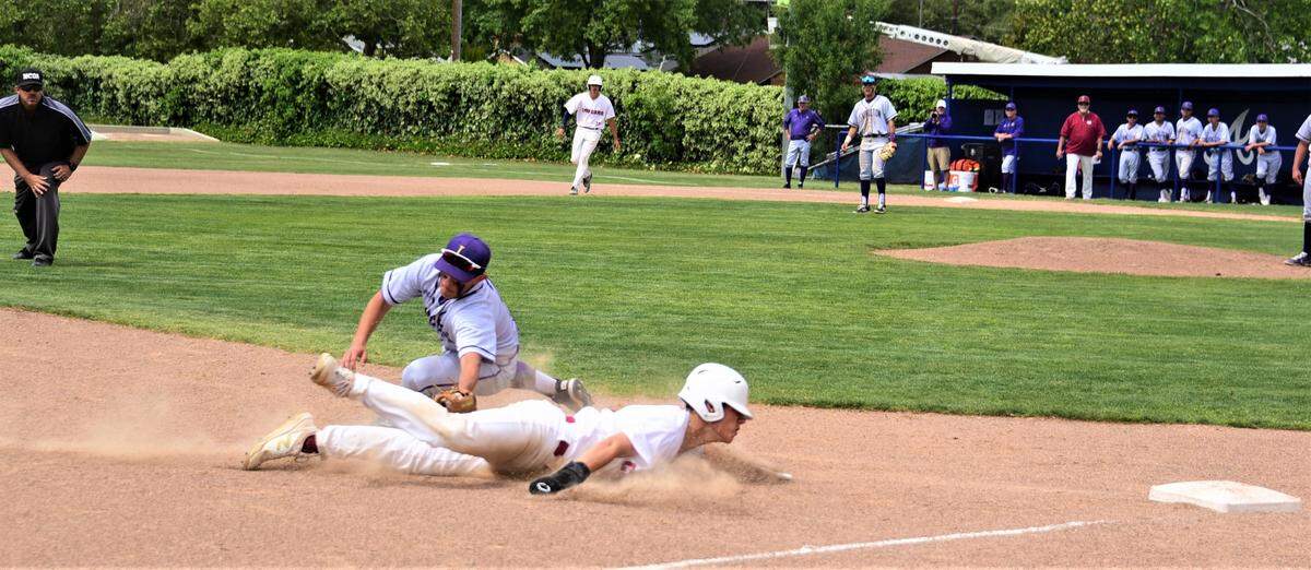 Golden Valley High sophomore Koen Heupel slides in safely at third base after avoiding a tag by Livingston third baseman AJ Orozco on stolen base attempt during a game on Monday, April 18, 2022 at Memorial Ballpark in Atwater, Calif.