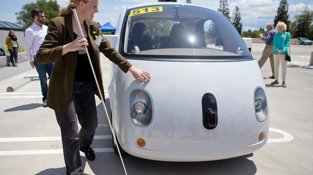 Jessie Lorenz of the Independent Living Resource Center in San Francisco, who is blind, touches the two-seater prototype of Google’s self-driving car at Google on May 13, 2015 in Mountain View, Calif. (LiPo Ching/Bay Area News Group/TNS)