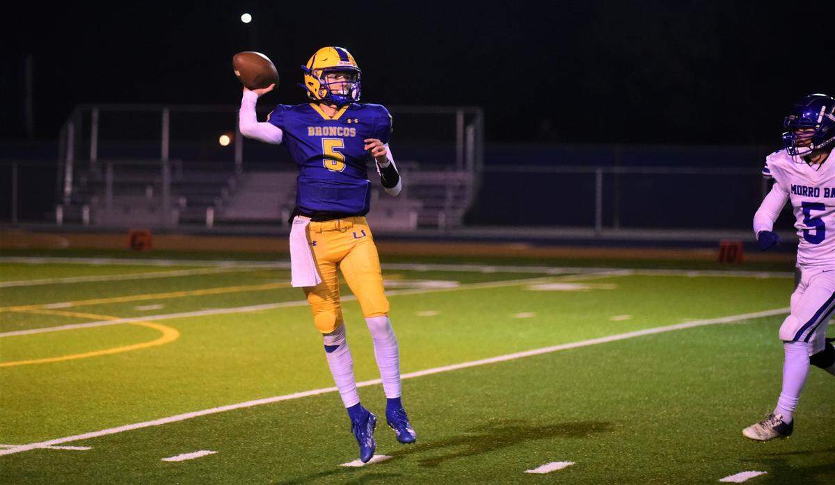 Dos Palos High School quarterback Peyton Van Worth throws a pass during a playoff game against Morro Bay on Thursday, Nov. 19, 2022.