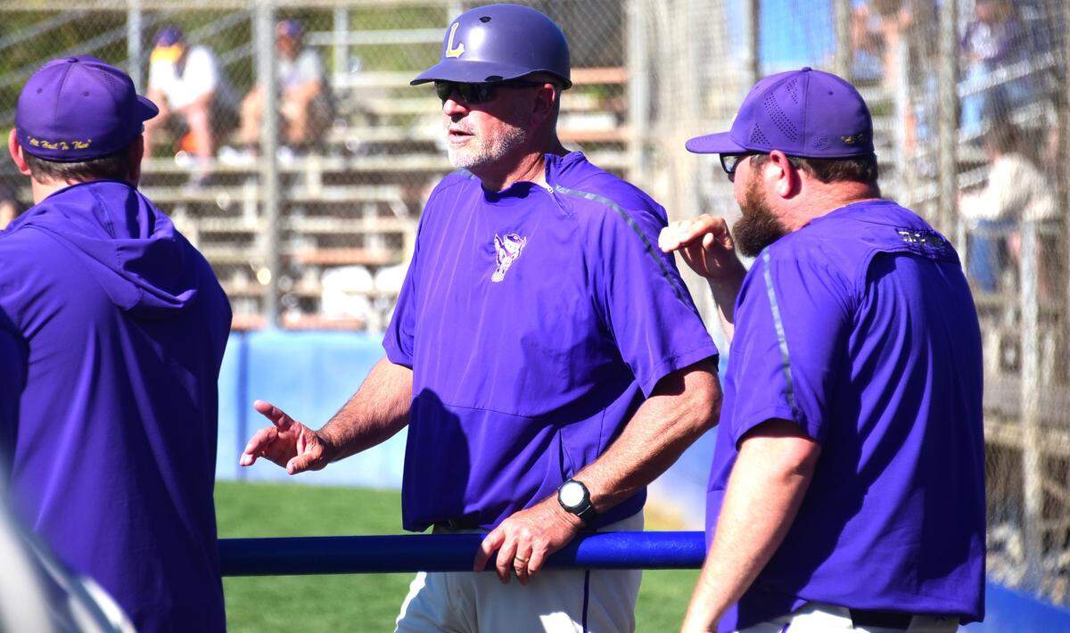 El entrenador de beisbol de Livingston High School, Matt Winton, charla con sus entrenadores asistentes durante un partido de los Wolves, el martes 2 de abril de 2024, en el Memorial Ballpark de Atwater. Winton ha entrenado a su alma mater durante 31 temporadas.