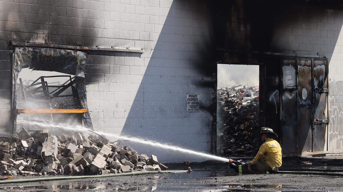 A Merced firefighter uses a hose to put out a fire at Merced Thrift Store on Aug. 21.