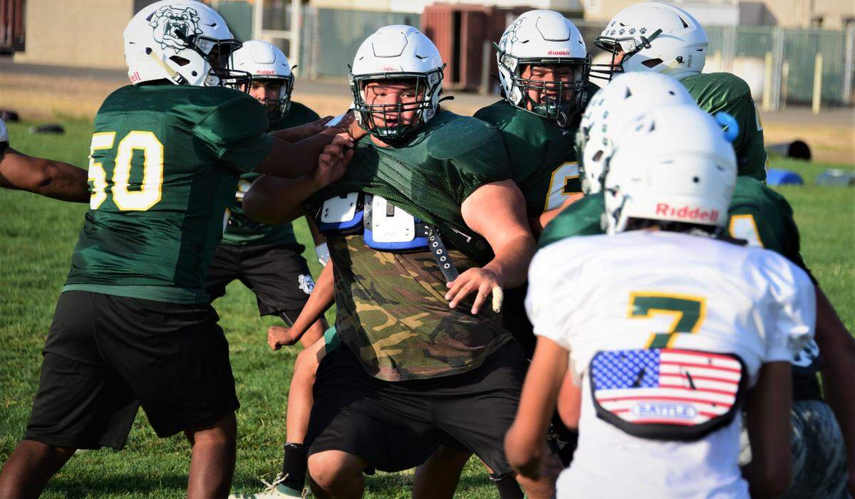 Le Grand High junior Fermin Villegas (center) works through a double-team during a defensive drill during a practice on Wednesday, Sept. 22, 2021 in Le Grand, Calif.