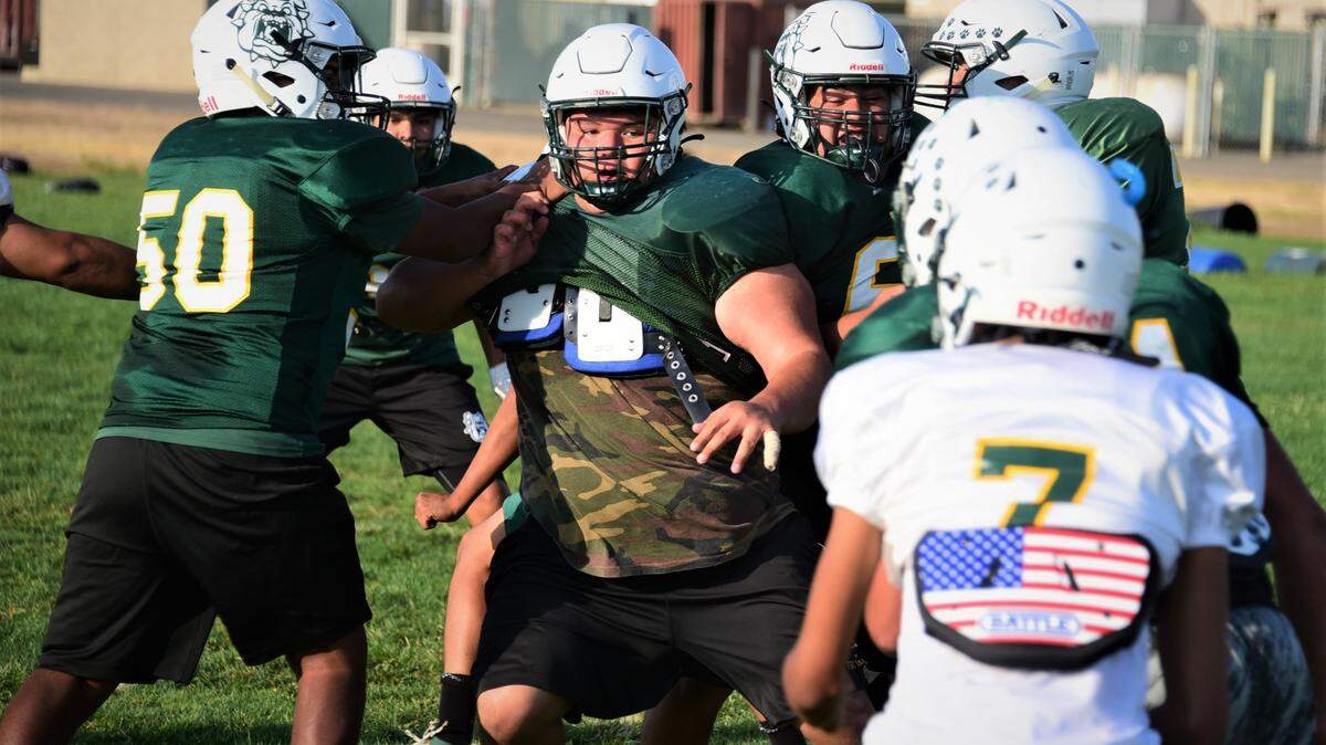 Le Grand High junior Fermin Villegas (center) works through a double-team during a defensive drill during a practice on Wednesday, Sept. 22, 2021 in Le Grand, Calif.